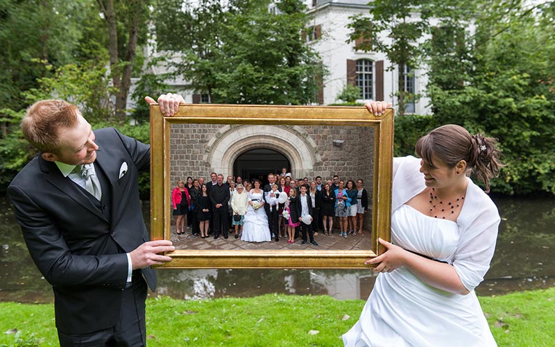 Couple de jeune mariée tenant un cadre photo dans le domaine 